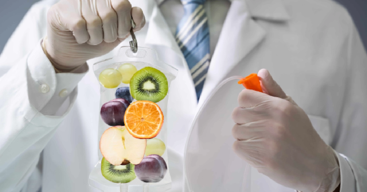 Doctor holding a vitamin infusion bag with fruits, representing IV Therapy in Scottsdale, AZ for energy, wellness, and overall vitality.