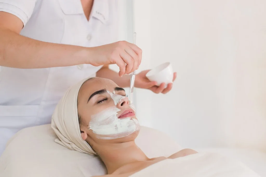 a woman lying down with a white mask on her face